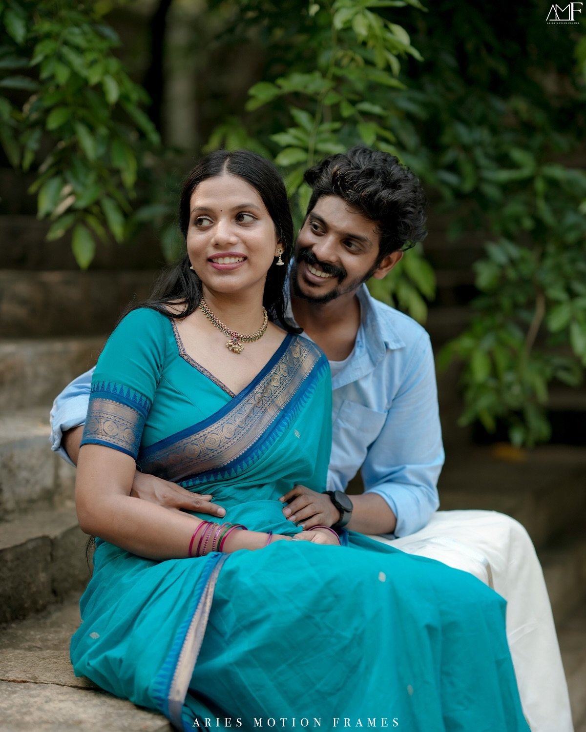 A couple in blue traditional attire sharing a close portrait