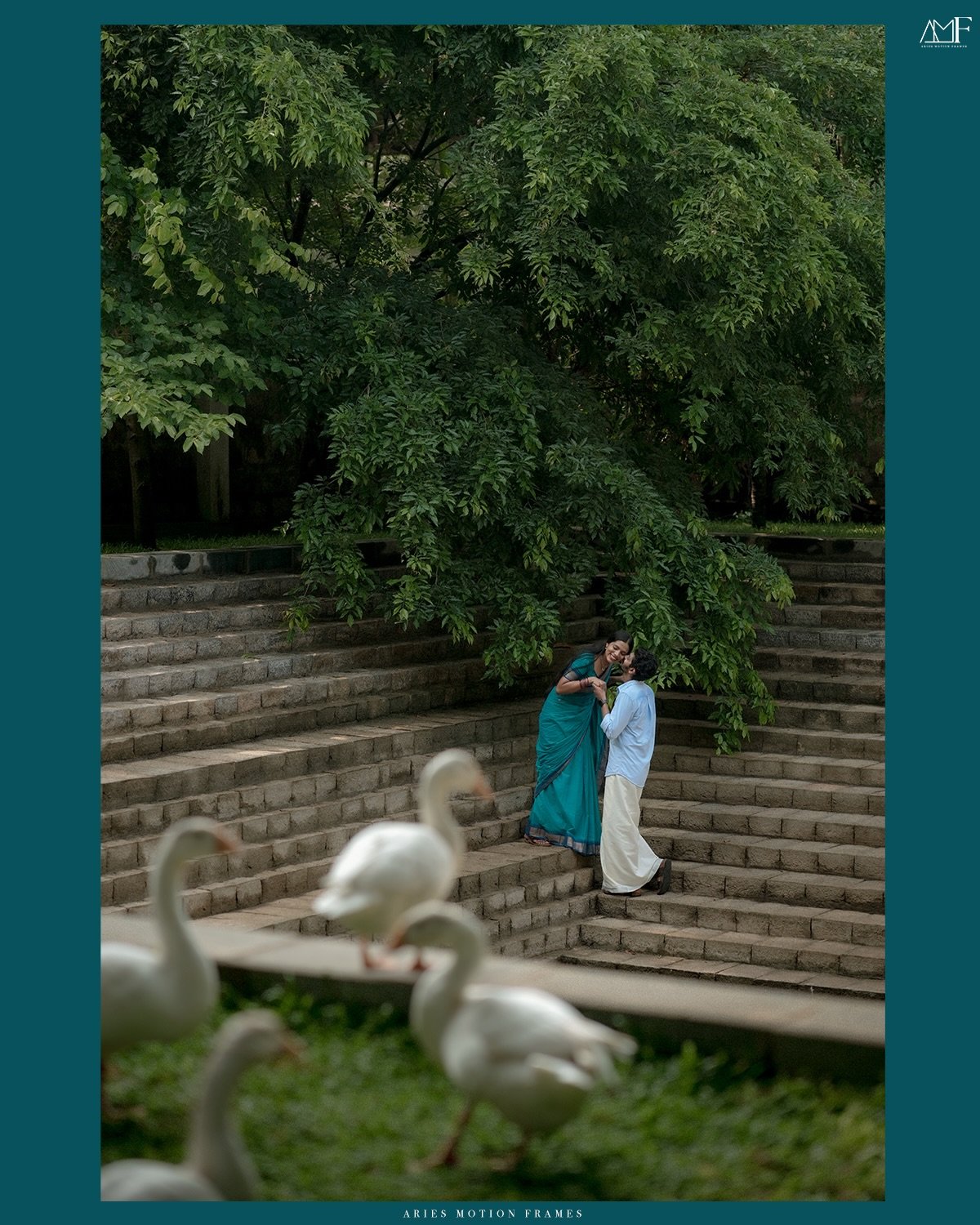 A couple sharing a playful moment beside a garden pond